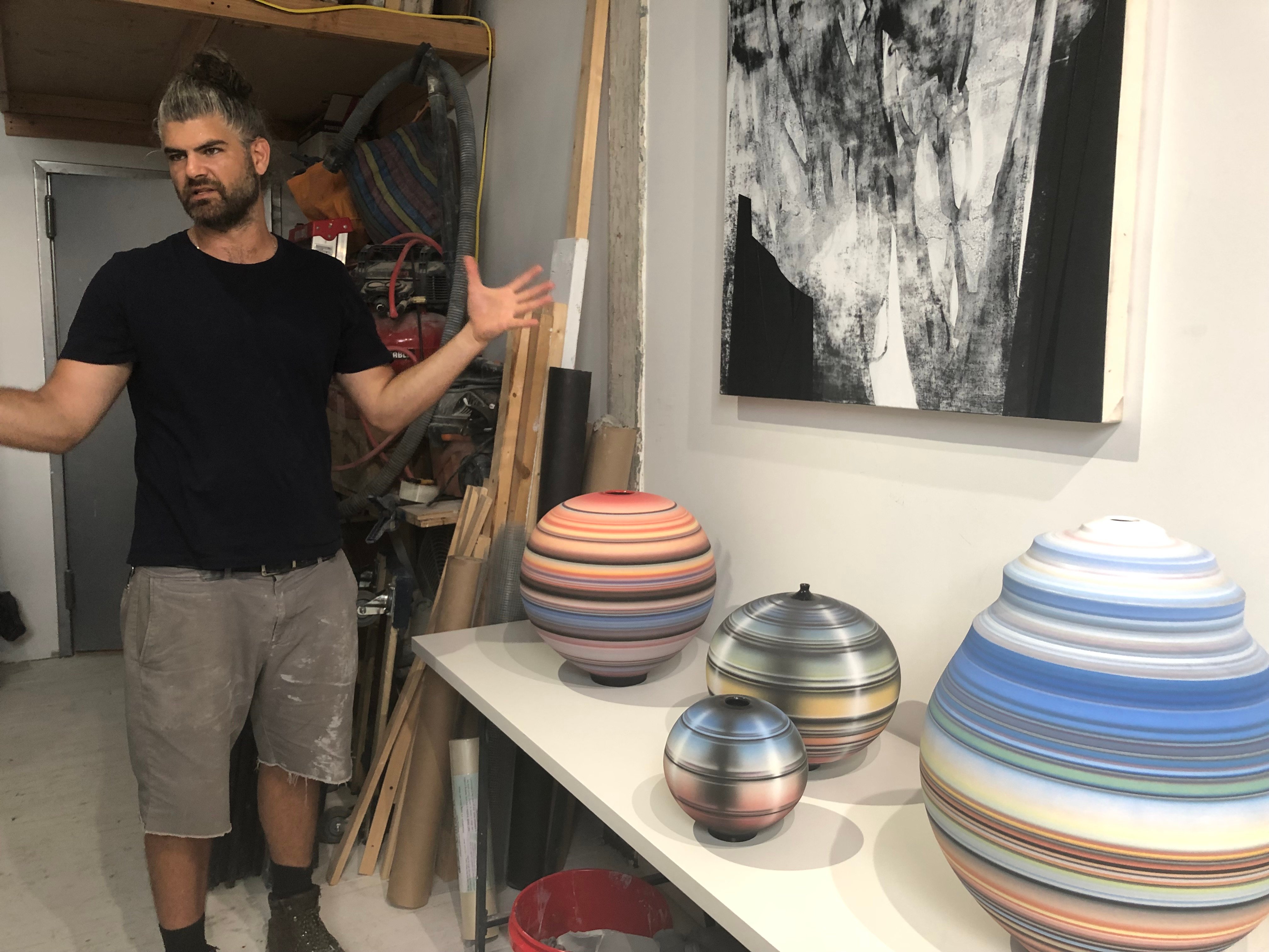 Artist Michael Dickey in his studio, showing ceramic sculptures and paintings